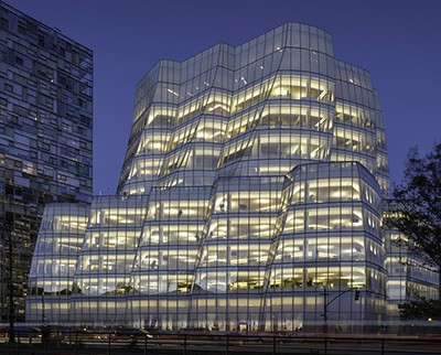 Modern wavy 11-story glass building at night